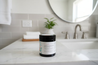 Jar of skincare product on a bathroom counter with a mirror and sink in the background